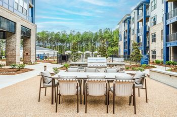 an outdoor patio area with a table and chairs and a grill at Preston Ridge, Cary, NC